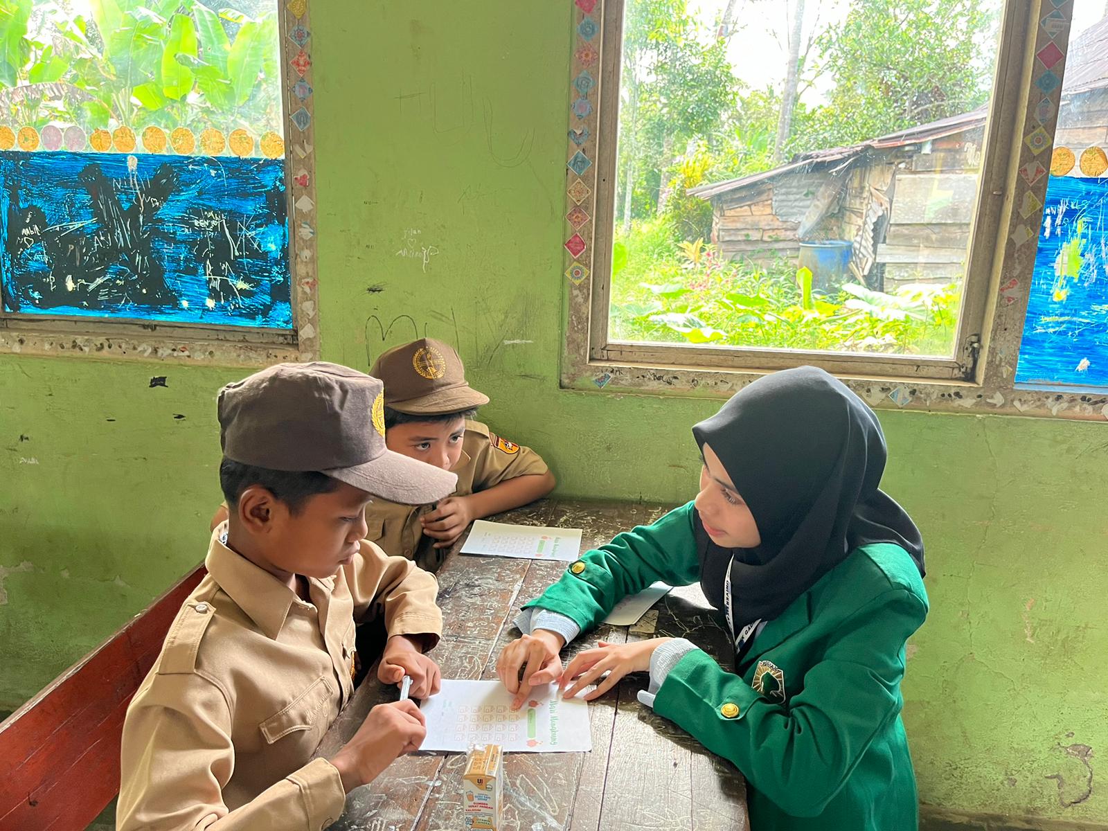 Salah satu mahasiswa KKN UNAND saat membantu kegiatan belajar mengajar di sekolah. (doc. KKN UNAND)