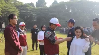 Rektor UNEJ, Iwan Taruna secara simbolis menyematkan atribut kepada perwakilan mahasiswa saat pelepasan peserta KKN, Rabu (10/07/2024). (doc. UNEJ)