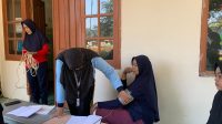 Mahasiswa KKN Posko 11 UIN Walisongo Semarang saat melakukan screening kesehatan yang diadakan di depan Posko KKN kelompok 11, Minggu (14/07/2024). (doc. KKN Posko 11 UIN Walisongo)