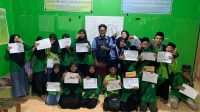 Mahasiswa KKN MIT 18 UIN Walisongo Semarang, Posko 35 dan para murid Madrasah Diniyah Awaliyah berfoto bersama menunjukkan hasil karya kaligrafi. (doc. Mahasiswa KKN MIT 18 UIN Walisongo Semarang, Posko 35)
