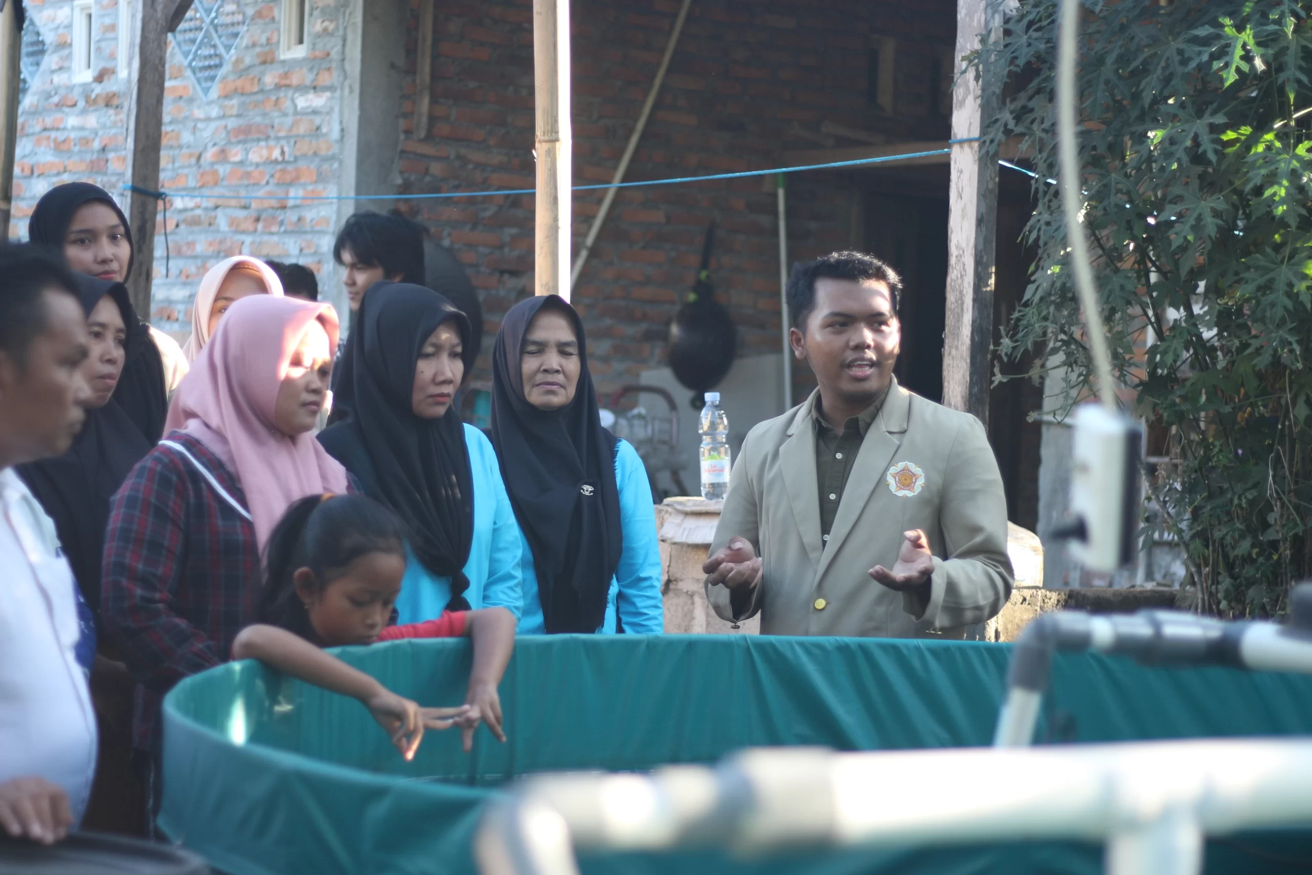 Samuel Kristo saat memberikan penjelasan mengenai prinsip kerja kolam budidaya RAS kepada masyarakat. (doc. Media dan Informasi Keluarga Mahasiswa Ilmu Perikanan)