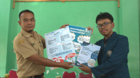 Mahasiswa KKN saat melakukan serah terima secara simbolis berupa poster dan booklet yang berisi informasi mengenai penerapan konsep 5S di Balai Desa Mlopoharjo, (22/7/2024). (doc. Pribadi)