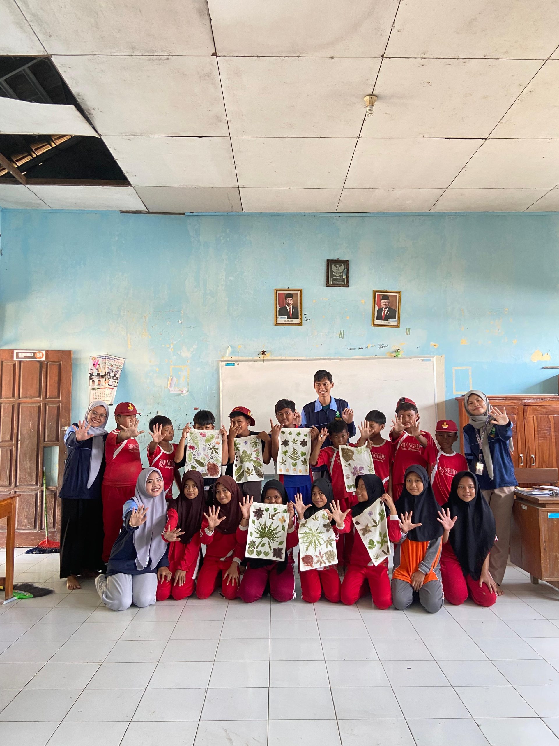 Para siswa SD Negeri Ngerjo peserta pelatihan Ecoprint dengan bangga menunjukan hasil karya mereka saat sesi foto bersama dengan mahasiswa KKN MIT-18 UIN Walisongo Semarang, Sabtu (03/08/2024). (doc. KKN MIT-18 UIN Walisongo Semarang)