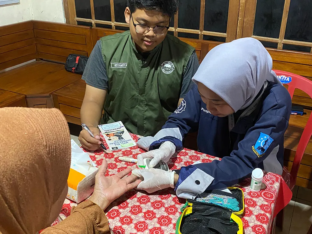 Mahasiswa KKN 79 UNS saat melakukan pemeriksaan gula darah. (doc. KKN 79 UNS)