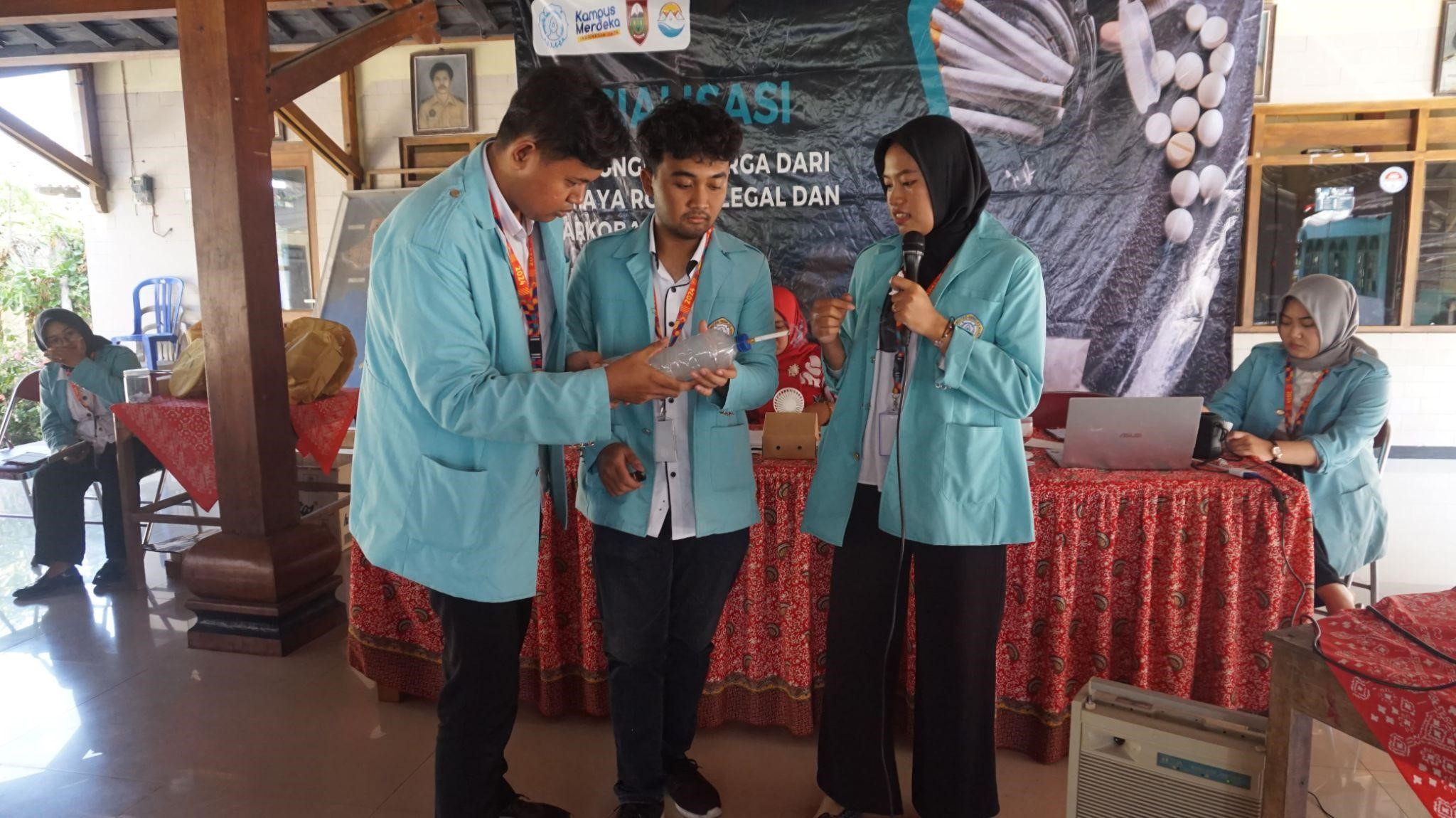 Mahasiswa KKN UNS menggunakan botol bekas dan kapas untuk menunjukkan kotornya paru-paru akibat merokok. (doc. Kelompok 39 KKN UNS)