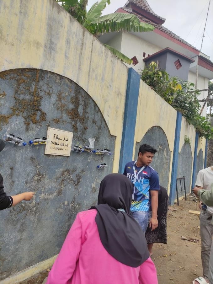 Proses pemasangan tanaman hidroponik kangkung di belakang Kantor Desa Wonoayu. (doc. KSM-T 59 Unisma)