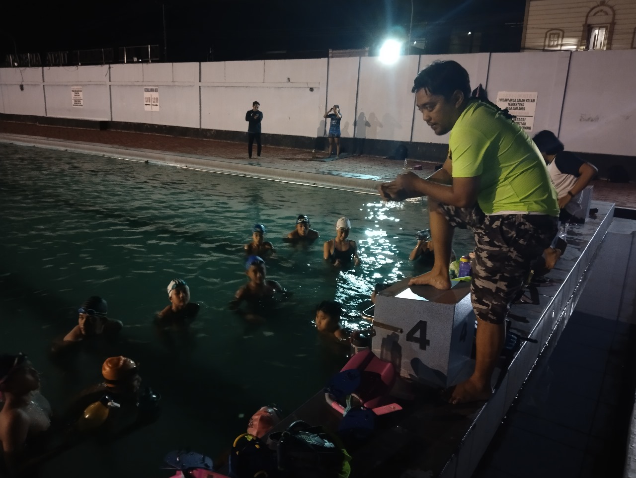Mahasiswa MBKM UNS saat memandu latihan malam di kolam Tirta Angkasa. (doc. Tim Hibah MBKM Renang SKO Surakarta, UNS)