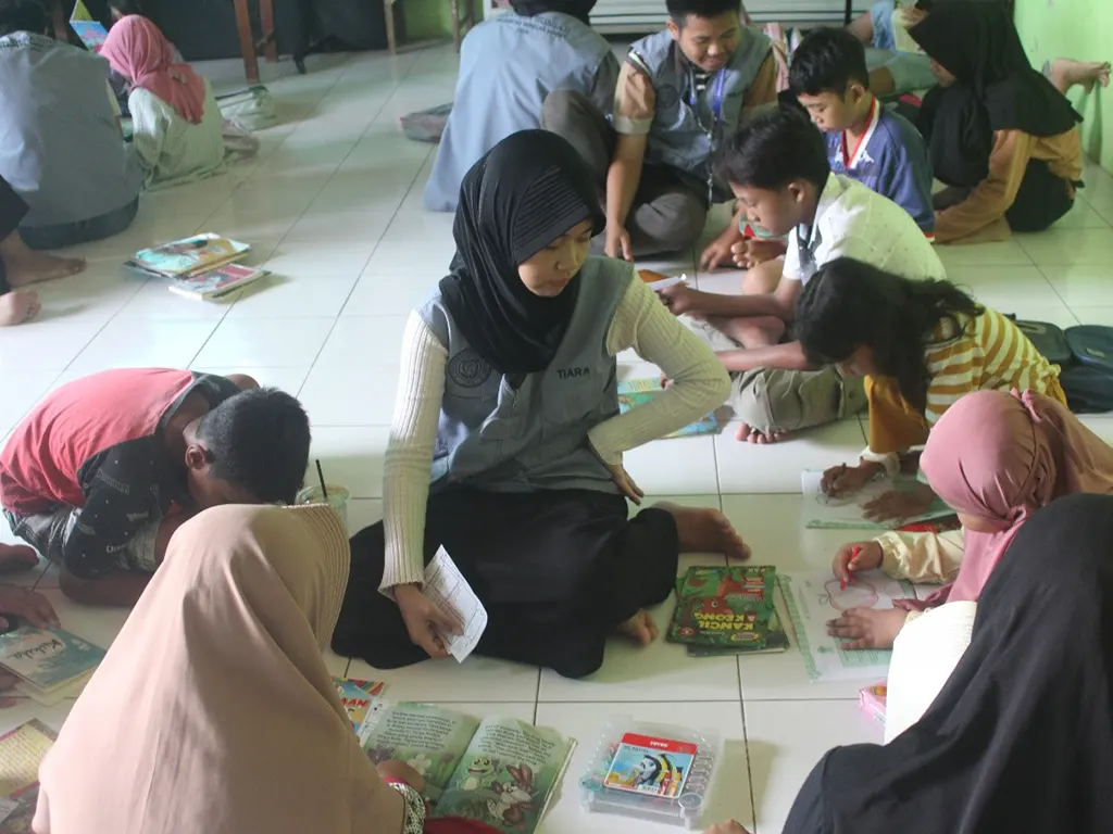 Kegiatan anak-anak membaca buku dengan duduk melingkar per kelompok dan dipandu oleh mahasiswa KKN. (doc. KKN UNS 92) Kegiatan anak-anak membaca buku dengan duduk melingkar per kelompok dan dipandu oleh mahasiswa KKN. (doc. KKN UNS 92)