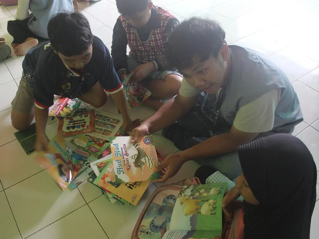 Kegiatan anak-anak membaca buku dengan duduk melingkar per kelompok dan dipandu oleh mahasiswa KKN. (doc. KKN UNS 92) Kegiatan anak-anak membaca buku dengan duduk melingkar per kelompok dan dipandu oleh mahasiswa KKN. (doc. KKN UNS 92)