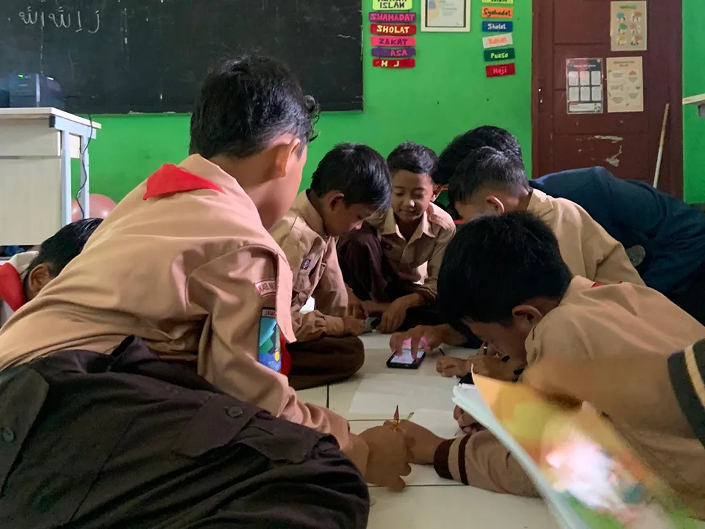 Mahasiswa KKN BBK 5 Unair saat mendamping para siswa dalam sesi menggambar kreatif. (doc. Pribadi)