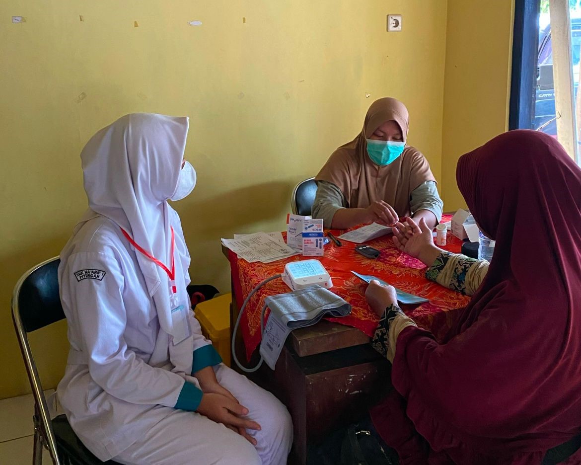 Petugas kesehatan dari Puskesmas Piyungan sedang melakukan cek gula darah kepada peserta cek kesehatan pada Sabtu (8/2/2025). (doc. KKN UMBY kelompok 28)