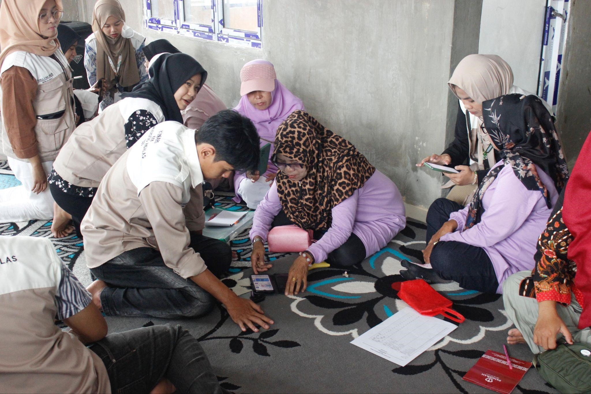 Proses pembuatan QRIS oleh Tim KKN UNAND bersama UMKM di Kinari. (doc. KKN UNAND)