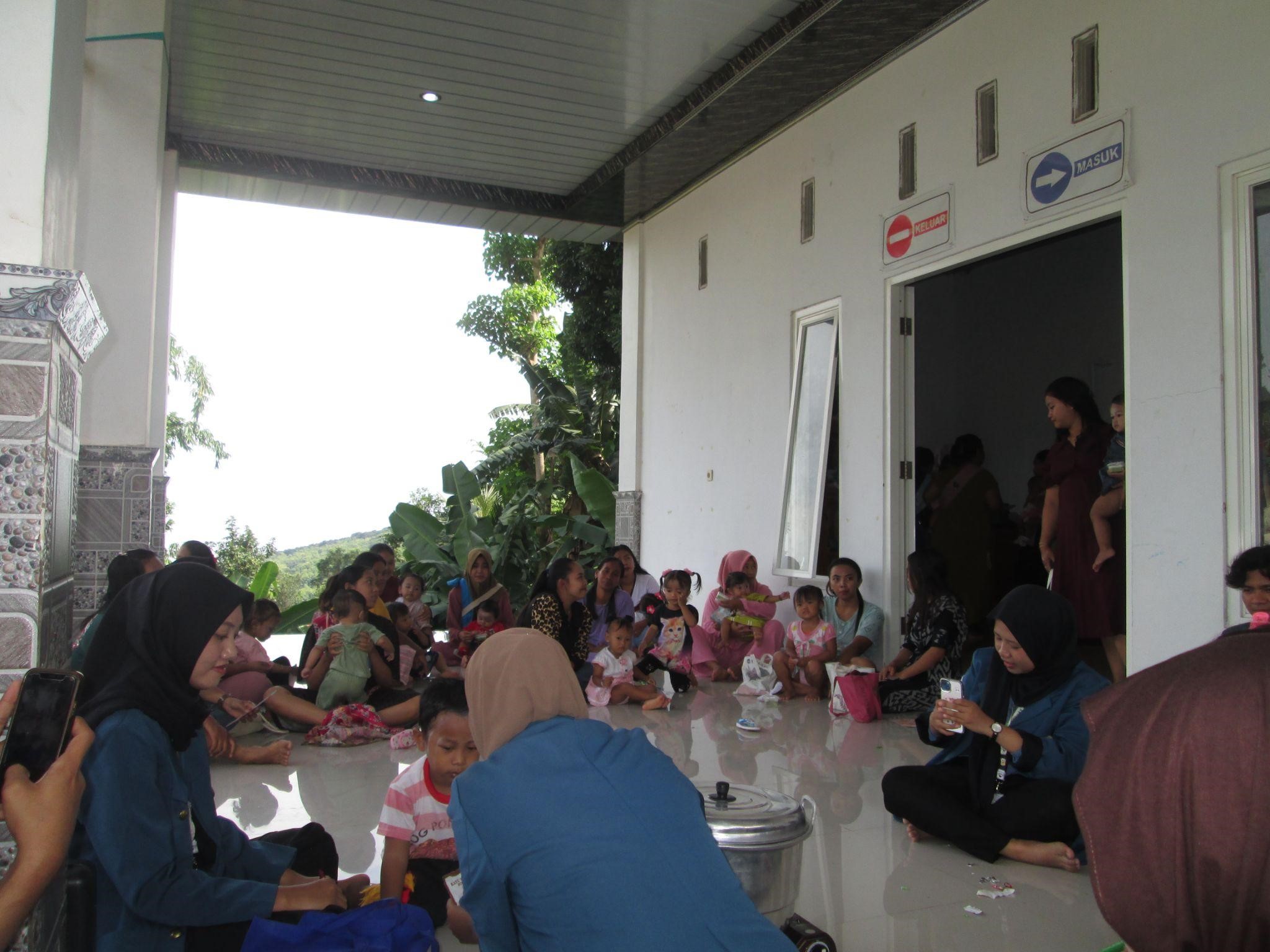 Mahasiswa KKN-BBK 5 Universitas Airlangga sedang melakukan live cooking MPASI dari pisang kepada ibu-ibu yang sedang menghadiri posyandu di Dusun Blentreng, Desa Ngembat (15/01/2025). (doc. Pribadi)