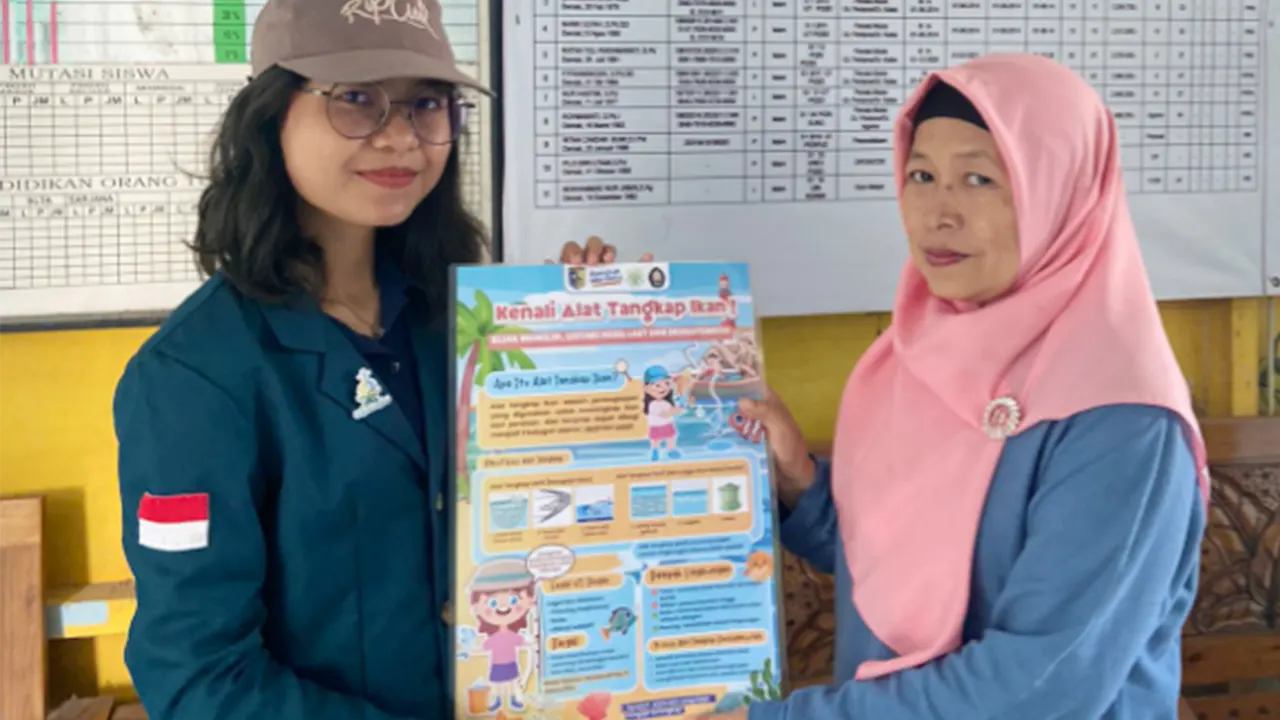 Mahasiswa UNDIP menyerahkan poster kepada pihak SDN 02 Tambakbulusan. (doc. Kelompok 1 KKN-T 35 UNDIP)