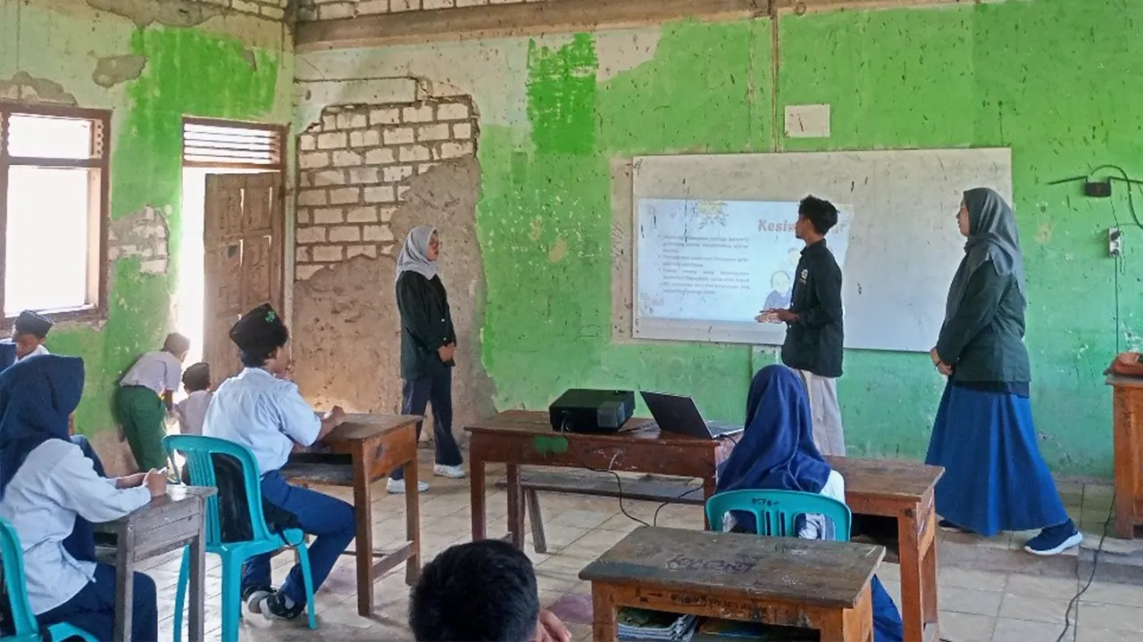 Para mahasiswa UINSA foto bersama dengan para guru MTs Wachid Hasyim di depan Gedung sekolah sebagai bentuk bukti terjalin kerja sama demi mewujudkan kegiatan sosialisasi moderasi beragama. (doc. Dewi/ salah sati siswa MTs Wachid Hasyim)