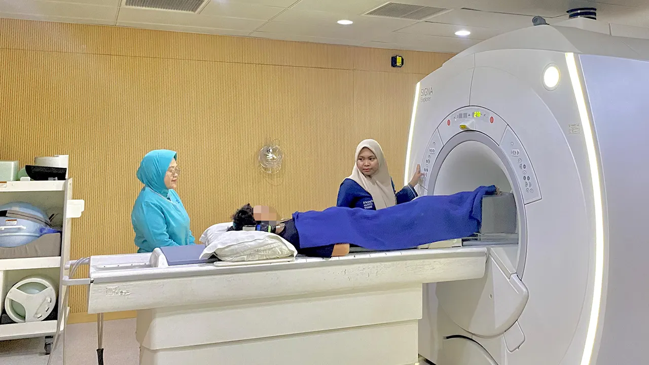 Salah satu mahasiswi magang melakukan positioning pada pasien sebelum pemeriksaan MRI Lutut dengan didampingi Clinical Instructor (doc. pribadi)
