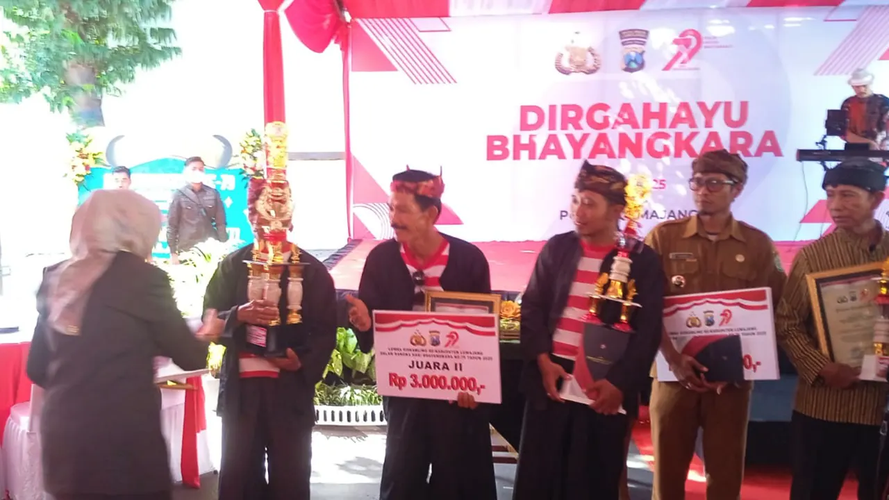 Bunda Indah saat memberikan piala penghargaan dan hadiah uang tunai kepada perwakilan Desa Rowokangkung. (doc. pribadi)