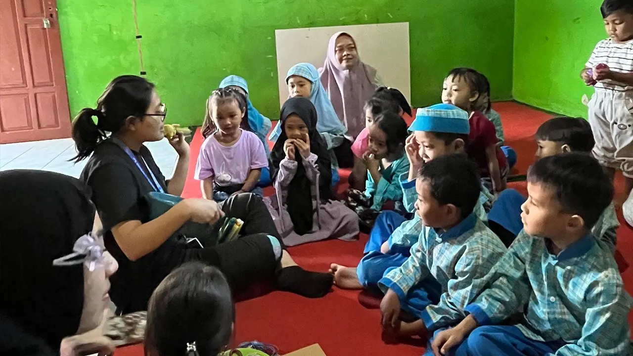 Mahasiswa KKN-T IPB memandu kegiatan meronce dengan memberikan instruksi kepada peserta didik untuk mengikuti pola tertentu (17/7/2025). (doc. pribadi)