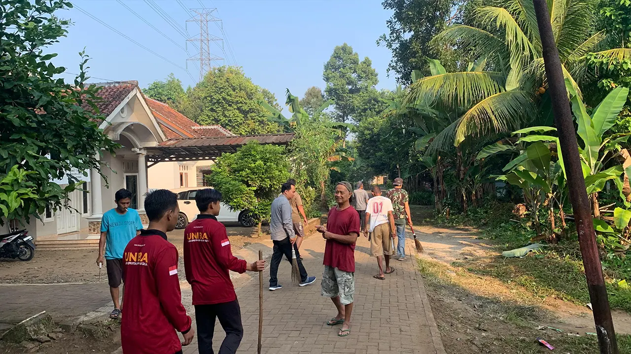 Masyarakat dan mahasiswa KKM Kelompok 31 UNIBA membersihkan jalan kampung sebagai bagian dari kegiatan rutin Jumat Bersih. (doc. KKM 31 UNIBA)