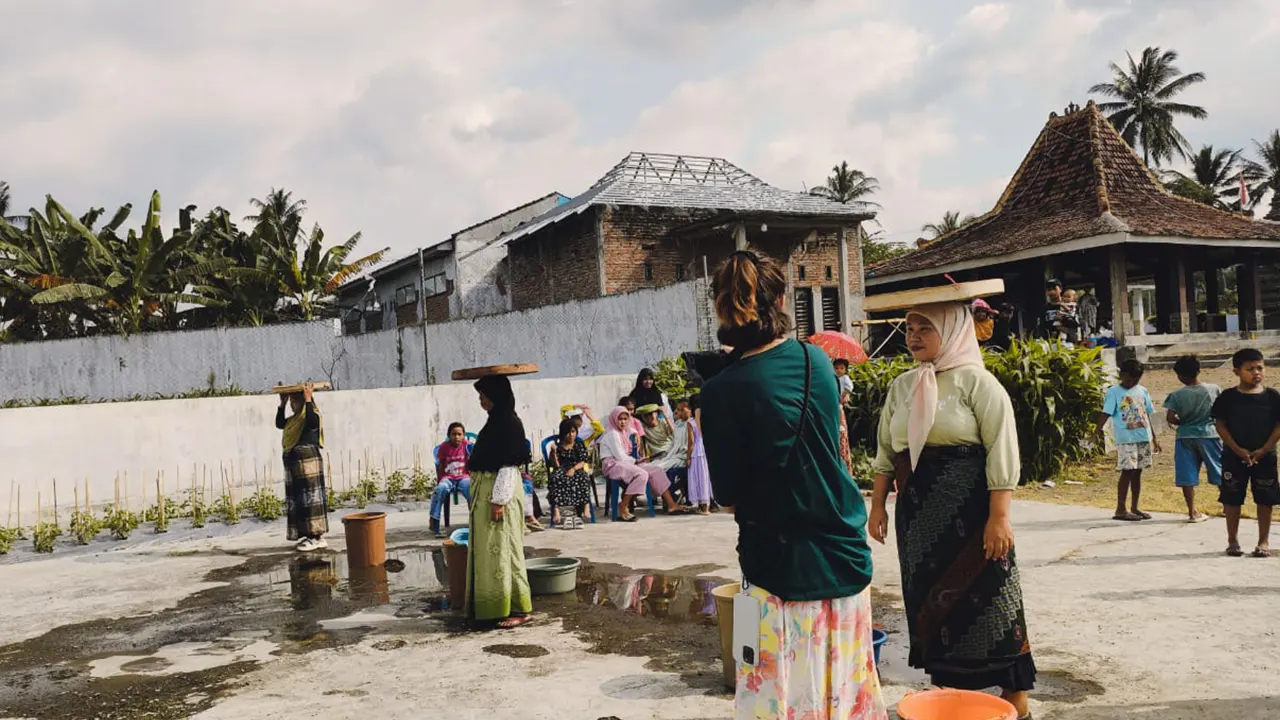 Turis asal Portugal terkesan saat melihat lomba permainan tradisional “Nyoon Gaddhang” Desa Sulek yang diselenggarakan oleh mahasiswa KKN 153 UINSA. (doc. KKN 153 UINSA)