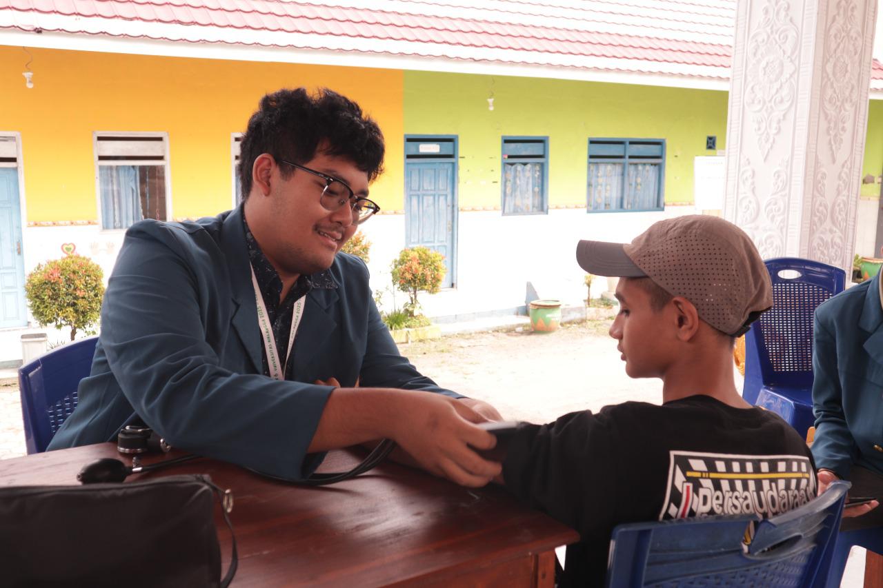 Tim Kesehatan BBK 6 UNAIR Cinandang melakukan pengecekan tekanan darah pada remaja. (doc. Mahasiswa BBK 6 UNAIR Cinandang)