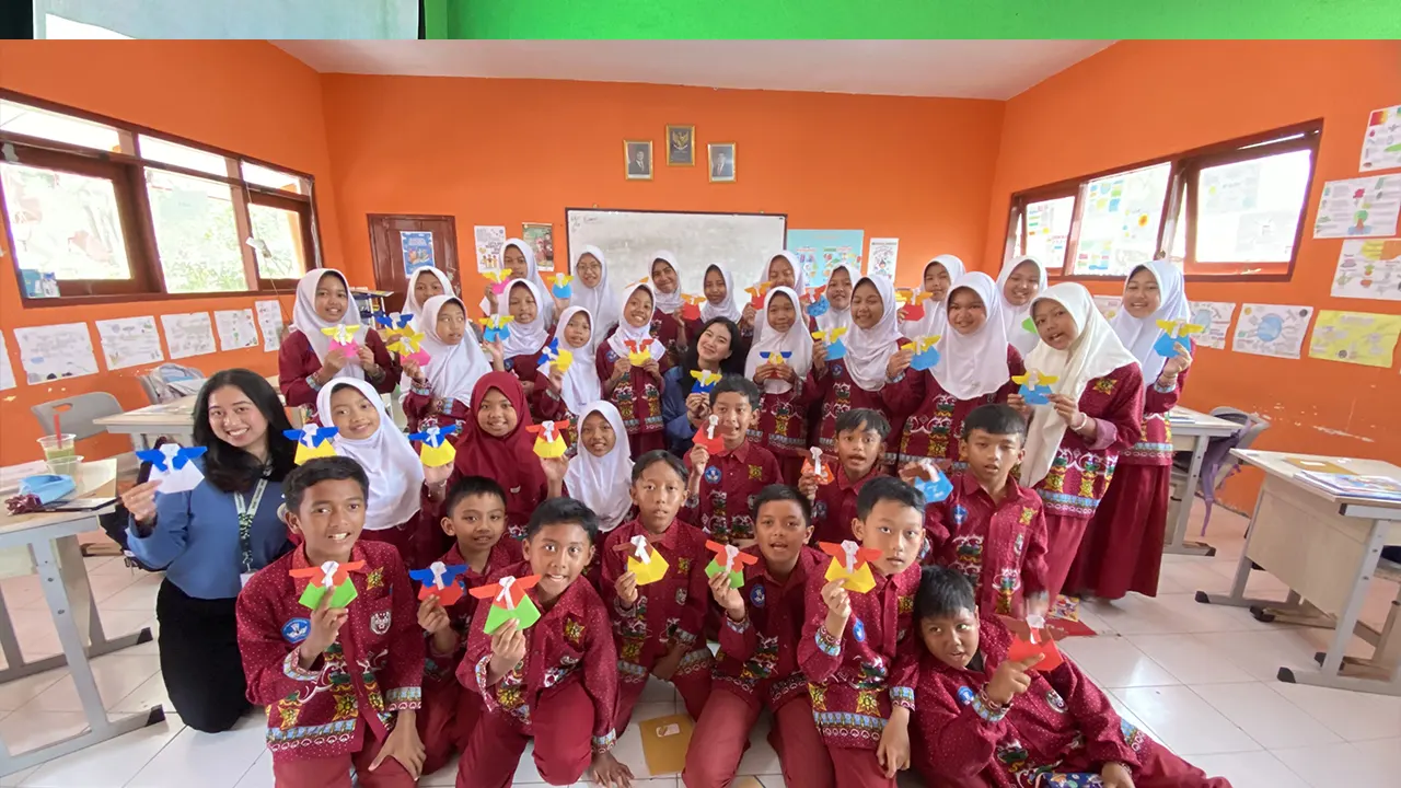 Dokumentasi bersama dangan menunjukan Hanbok, pakaian tradisional Korea, dari kertas origami hasil kreasi para siswa. (doc. pribadi)