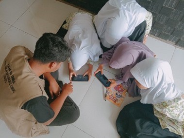 Mahasiswa KKM 10 UNIBA saat mendapingi anak-anak bermain Game edukasi anak "Suku Terlupakan Mencari Keris Legenda". (doc. KKM 10 UNIBA)