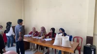 Mahasiswa KKM 55 UNIBA bersama pemerintah Desa Jatimulya menyalurkan bantuan beras kepada warga, Senin (21/7/2025). (doc. KKM 55 UNIBA)
