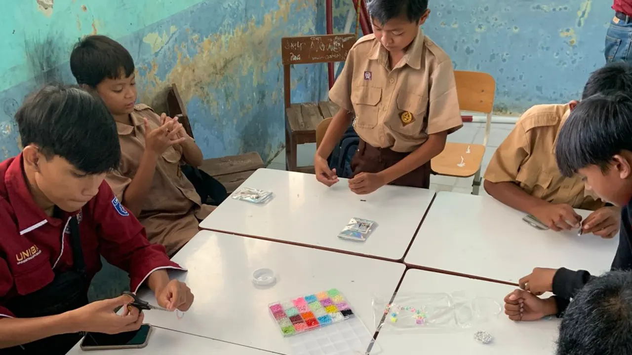 Mahasiswa KKM 75 UNIBA mendampingi siswa saat pelaksanaan kegiatan meronce. (doc. KKM 75 UNIBA)