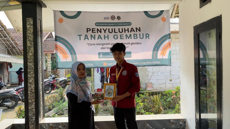 Mahasiswa KKM 75 juga memberikan logo KWT Dahlia yang didesain khusus oleh mahasiswa beserta benih sayuran kepada Ketua KWT, Ibu Iyan. (doc. KKM 75 UNIBA)