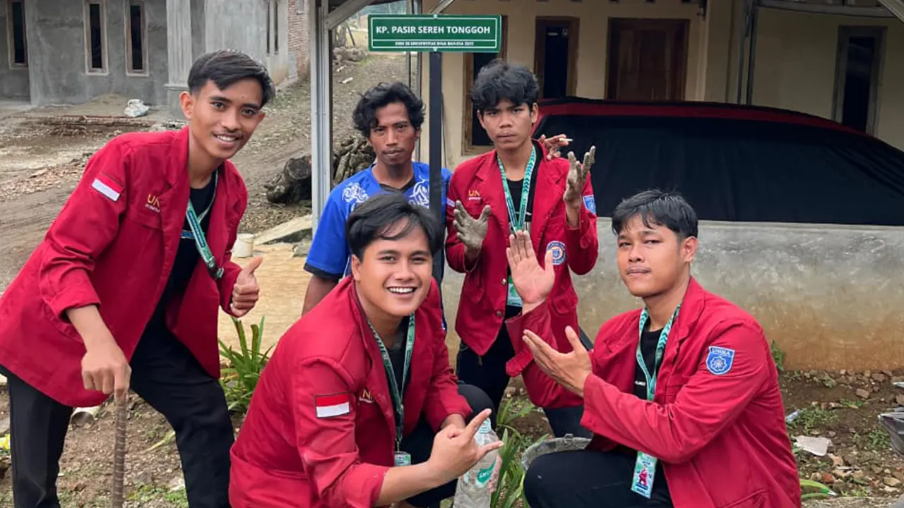 Mahasiswa KKM Kelompok 28 UNIBA bersama warga Desa Tegal berpose di depan plang jalan baru ‘Kp. Pasir Sereh Tonggoh’ yang mereka pasang sebagai penanda lokasi dan batas wilayah desa. (doc. KKM 28 UNIBA)