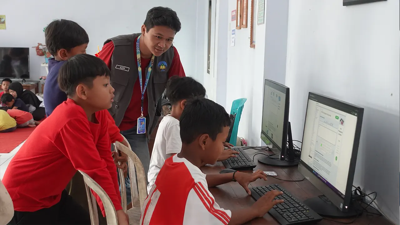 Mahasiswa KKN 178 UNS saat mendamping anak-anak Desa Butuh mengoperasikan komputer. (doc. KKN 178 UNS)