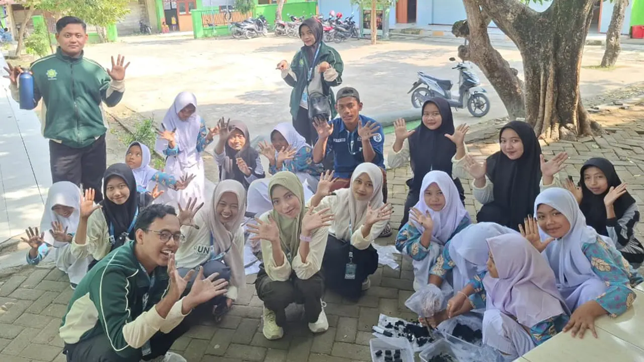 Mahasiswa KKN Pintar Unugiri Kelompok 55 bersama siswa-siswi SMP Satu Atap Desa Soko berpose ceria usai mengikuti pelatihan pembuatan briket dari bonggol jagung. (doc. KKN 55 Unugiri)
