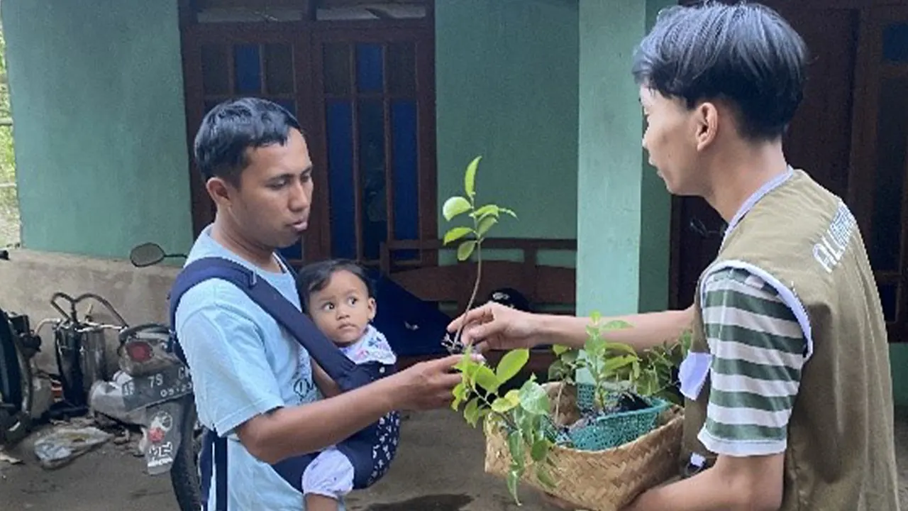 Mahasiswa KKN UMBY Kelompok 45 saat memberikan satu bibit pohon sirsak setiap rumah di Padukuhan Rejosari. (doc. KKN UMBY Kelompok 45)