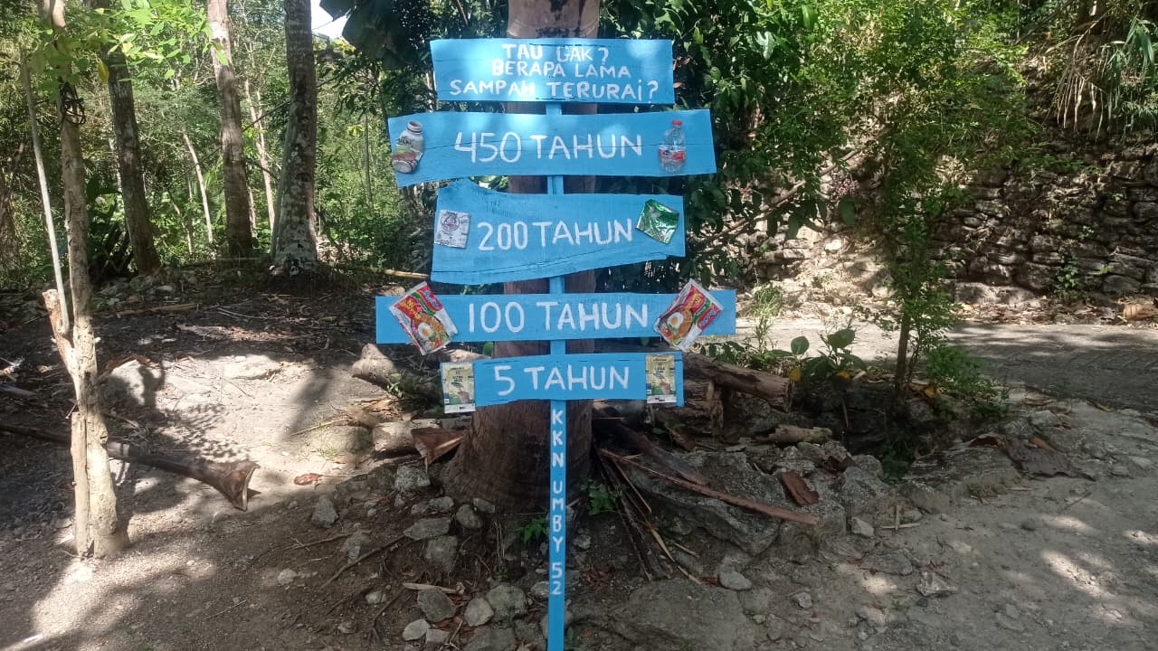 Plang edukasi sampah buatan mahasiswa KKN 52 UMBY di Dusun Badean, Bantul, memuat informasi waktu terurai berbagai jenis sampah untuk meningkatkan kesadaran warga menjaga kebersihan lingkungan. (doc. KKN UMBY 52)