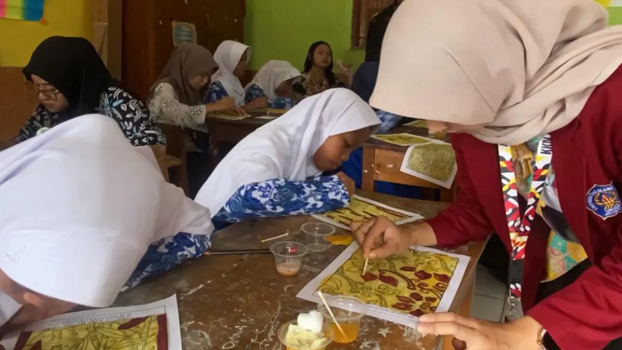 Rofi’ Hani Hangganingtyas saat mendampingi siswa mewarnai motif batik dengan larutan asam dan basa. (doc. pribadi)
