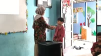 Seorang mahasiswa KKN UINSI Sidomulyo Samarinda Ilir memberikan pertanyaan kepada siswa SDN 008 Samarinda Ilir dalam kegiatan sosialisasi gemar menabung sejak dini, Rabu (30/7/2025). (doc. KKN UINSI Sidomulyo Samarinda Ilir)