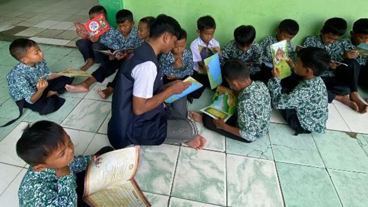 Siswa Madrasah Ibtidaiyah Desa Bojot mengikuti sesi membaca bersama pendamping dari Perpustakaan Provinsi Banten dalam kegiatan Mobil Pintar dan Perpustakaan Keliling hasil kolaborasi dengan KKM 85 UNIBA. (doc. KKN 85 UNIBA)