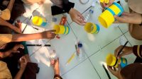 Siswa SDN 2 Tambakan fokus mewarnai dan menempel kertas untuk membuat baju dungaree Minions dari botol bekas, sambil belajar konsep 5R melalui praktik kreatif. (doc. KKN 107 UNS)