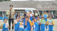 Siswa-siswi SDN Bencongan 2 antusias menunjukkan buku bacaan pilihan mereka dari layanan perpustakaan keliling yang dihadirkan KKM Tematik Literasi 43 Untirta bersama mitra. (doc. KKM Tematik Literasi 43 Untirta)