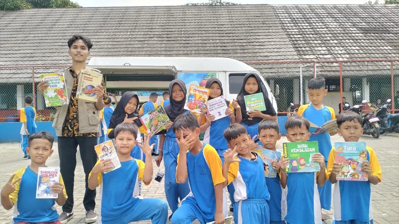 Siswa-siswi SDN Bencongan 2 antusias menunjukkan buku bacaan pilihan mereka dari layanan perpustakaan keliling yang dihadirkan KKM Tematik Literasi 43 Untirta bersama mitra. (doc. KKM Tematik Literasi 43 Untirta)