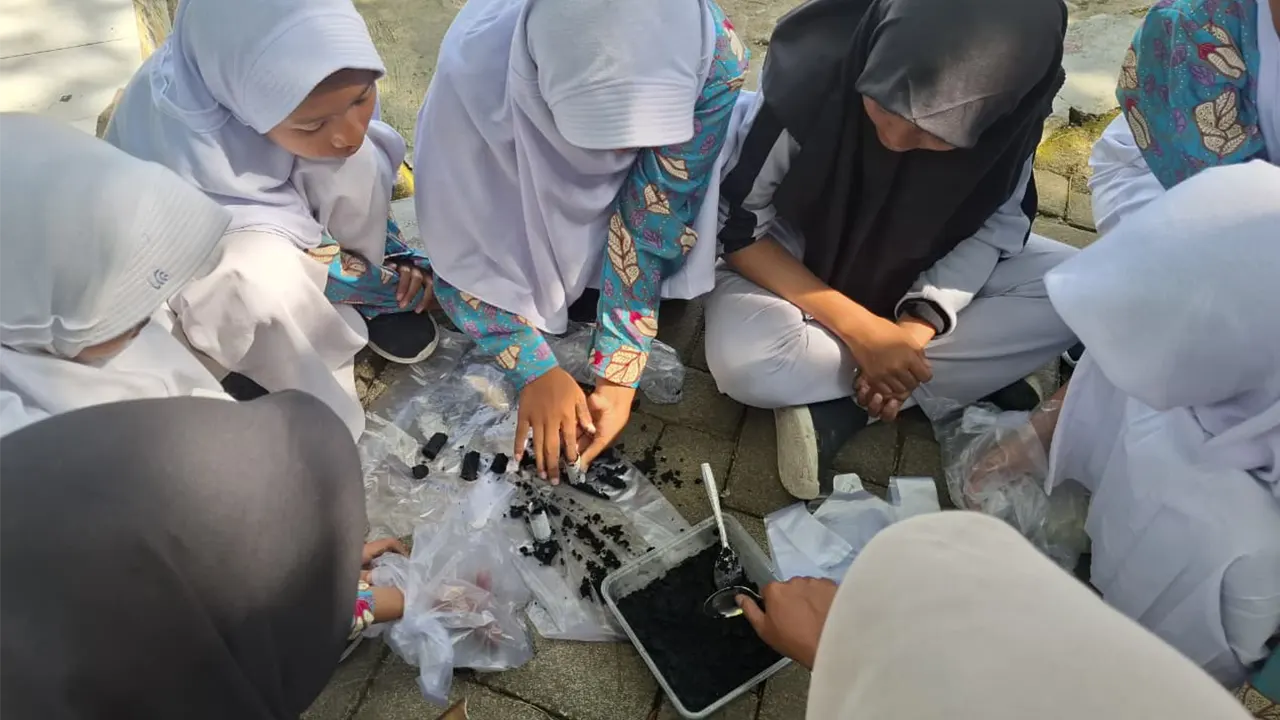 Siswa-siswi SMP Satu Atap Desa Soko antusias mengikuti praktek pembuatan briket dari bonggol jagung yang dipandu mahasiswa KKN Pintar Unugiri Kelompok 55. (doc. KKN 55 Unugiri)