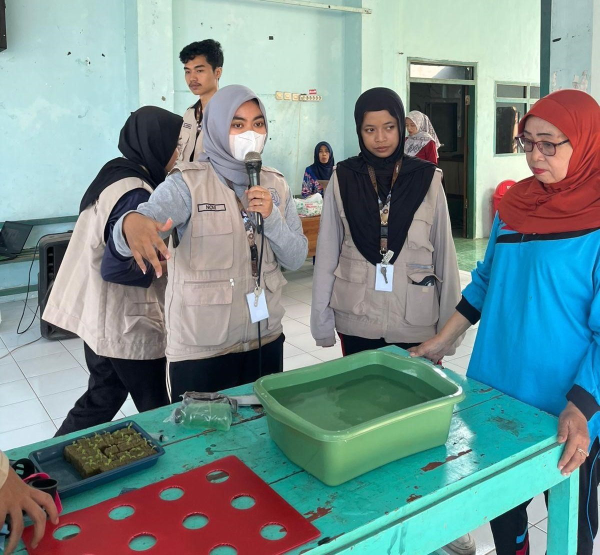 Mahasiswa KKN UNS 227 memberikan penjelasan praktik pembuatan instalasi hidroponik rakit apung kepada ibu-ibu PKK Desa Banjarejo, Kecamatan Rejoso, Kabupaten Nganjuk. (doc. KKN 227 UNS)