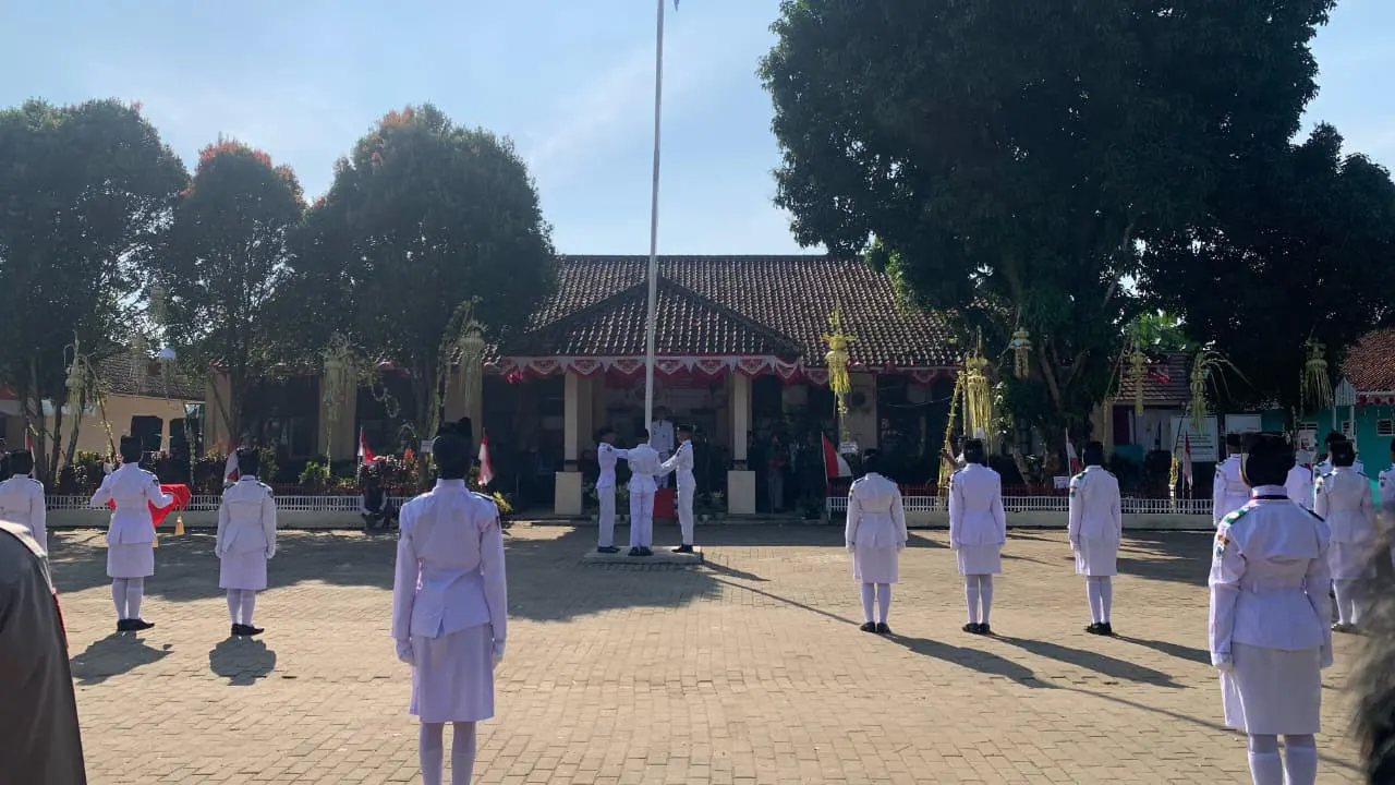 Suasana khidmat saat pengibaran Sang Merah Putih dalam upacara peringatan kemerdekaan di Kecamatan Cikedal. (doc. KKM 31 UNIBA)