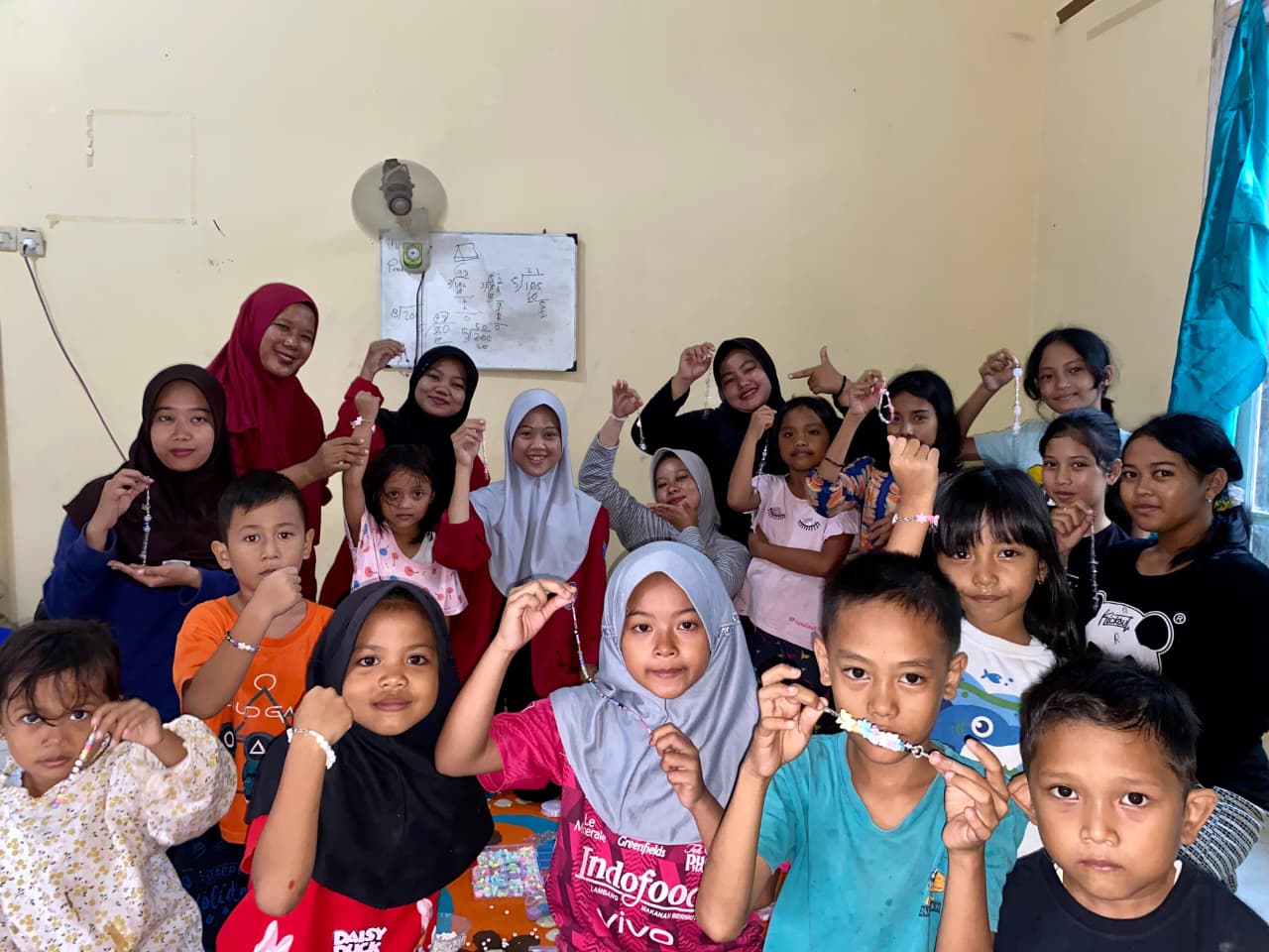 Anak-anak Desa Nameng bersama mahasiswa KKM UNIBA kelompok 58 dengan bangga menunjukkan hasil karya gelang dan aksesoris dari kegiatan meronce manik-manik di Posko KKM, Minggu (10/8/2025). (doc. KKM 58 UNIBA) Anak-anak Desa Nameng bersama mahasiswa KKM UNIBA kelompok 58 dengan bangga menunjukkan hasil karya gelang dan aksesoris dari kegiatan meronce manik-manik di Posko KKM, Minggu (10/8/2025). (doc. KKM 58 UNIBA)