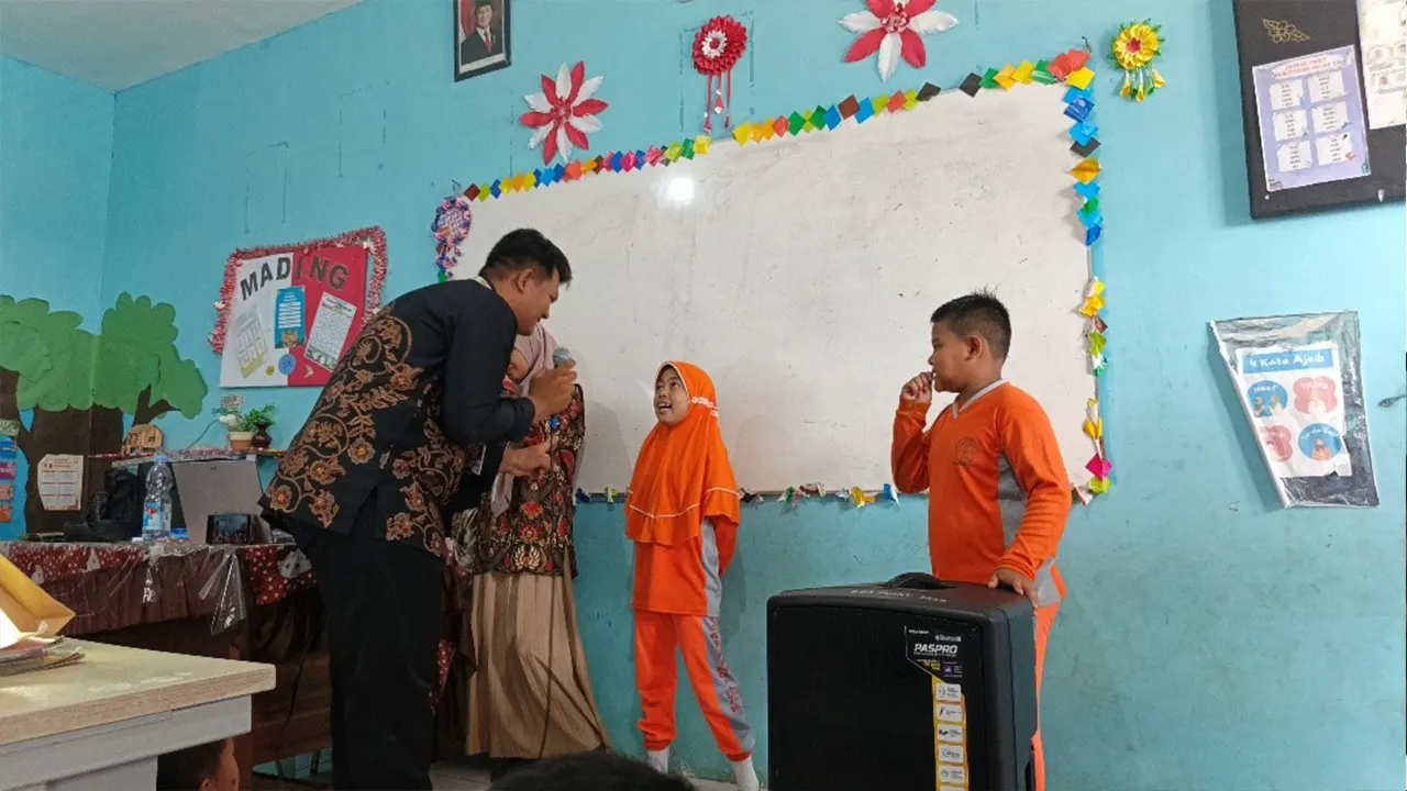 Seorang mahasiswa KKN UINSI Sidomulyo Samarinda Ilir memberikan pertanyaan kepada siswa SDN 008 Samarinda Ilir dalam kegiatan sosialisasi gemar menabung sejak dini, Rabu (30/7/2025). (doc. KKN UINSI Sidomulyo Samarinda Ilir)