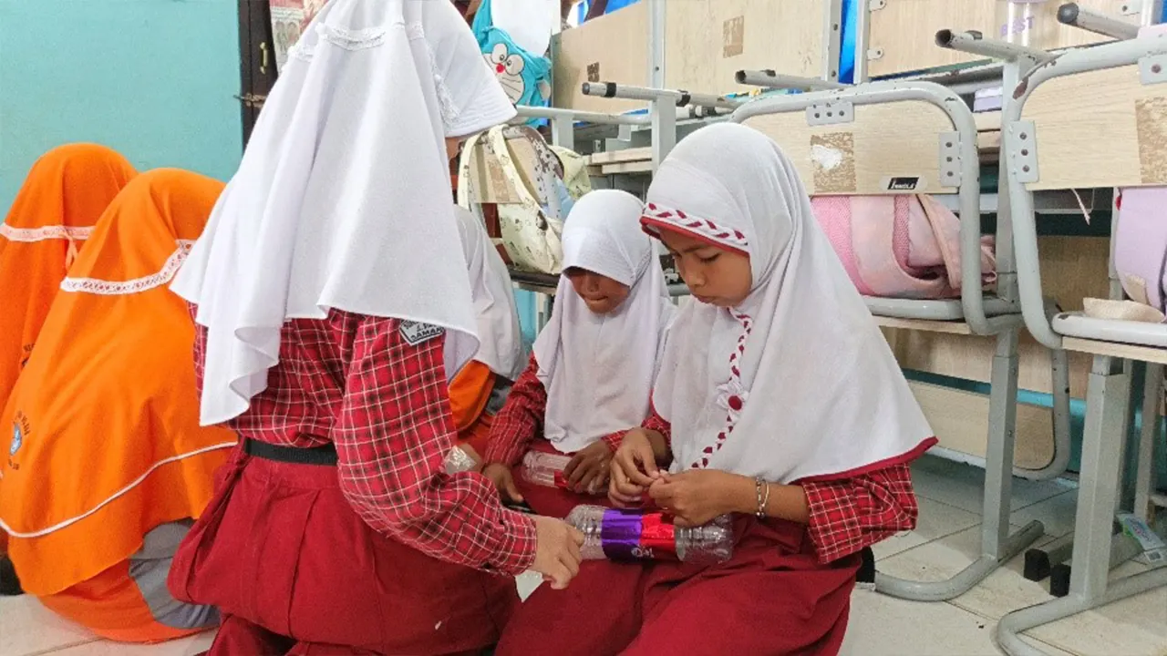 
Siswi SDN 008 Samarinda Ilir serius menghias celengan dari botol bekas dalam kegiatan kreatif literasi keuangan yang diadakan tim KKN UINSI Sidomulyo, Rabu (30/7/2025). (doc. KKN UINSI Sidomulyo Samarinda Ilir)
