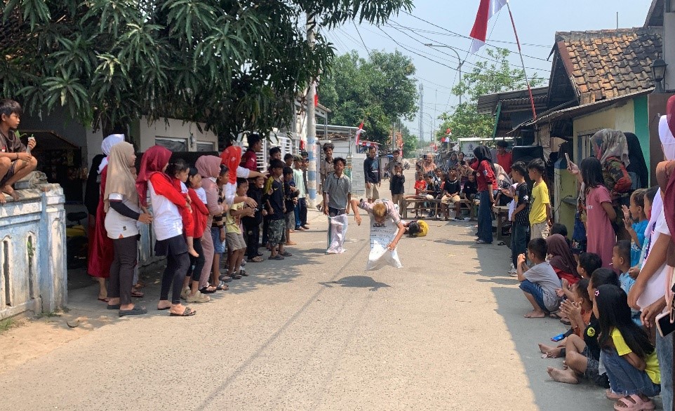 Anak-anak Kampung Bayak dengan penuh semangat mengikuti lomba balap karung 17 Agustus, disaksikan warga yang antusias memberi dukungan. (doc. KKM 95 UNIBA)