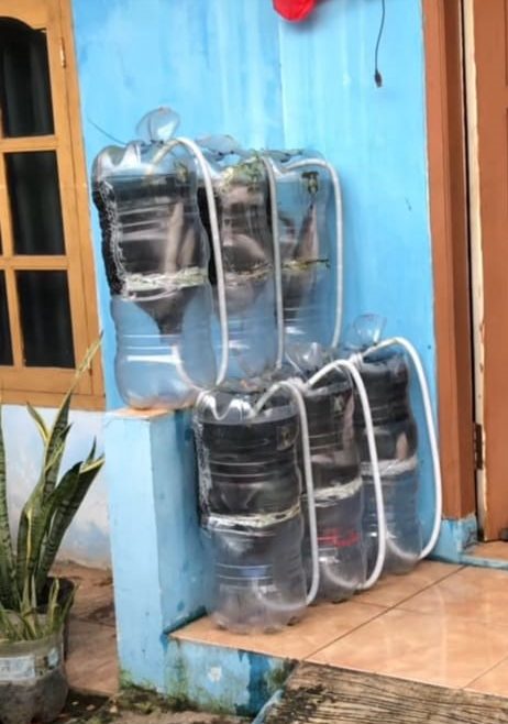 Contoh penggunaan media budidaya ikan lele dalam galon bekas di lahan sempit (teras depan rumah). (doc. KKN 244 UNS)