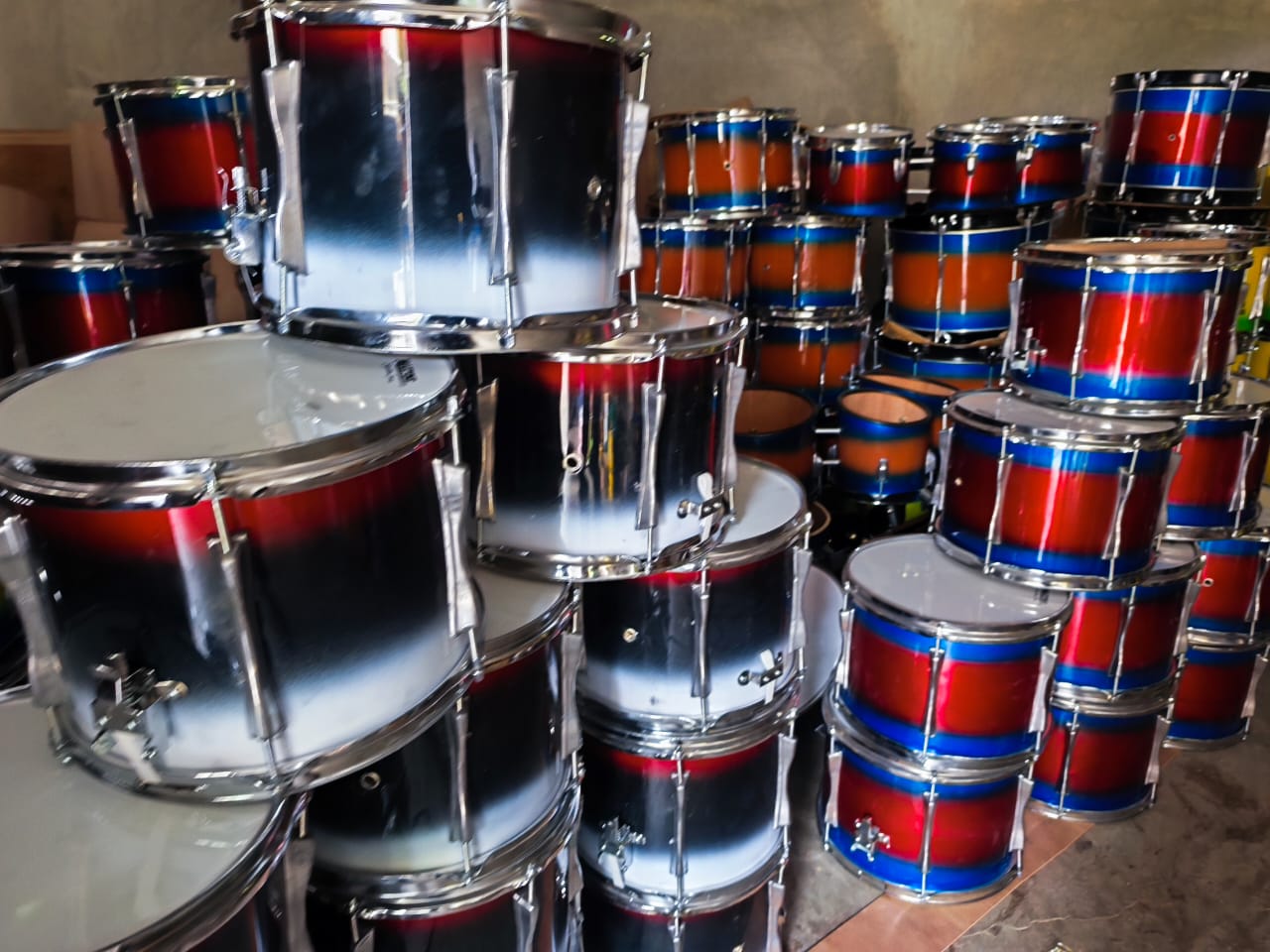 Tumpukan alat drumband siap kirim dengan warna menarik dan kualitas terbaik dari pengrajin lokal. Sumber: naydrumband.com